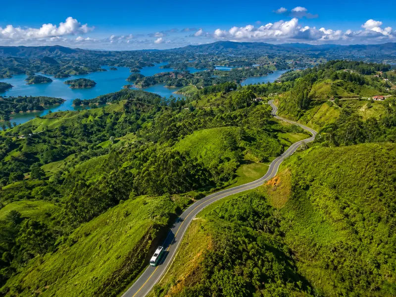 Aerial view of the winding road from Medellín through green hills toward the Guatapé reservoir